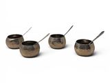 four small bowls with spoons are lined up on a white surface