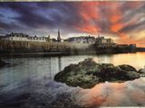 tableau représentant un coucher de soleil sur un plan d'eau, avec un château en arrière-plan