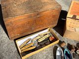 a wooden box with a pair of shoes and a pair of scissors in it