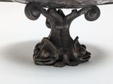 a bird sitting on top of a birdbath on a table