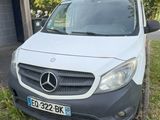 une camionnette blanche garée devant un immeuble, sur la pelouse