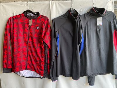 two men ' s jackets hanging on a clothes rack in front of a wall