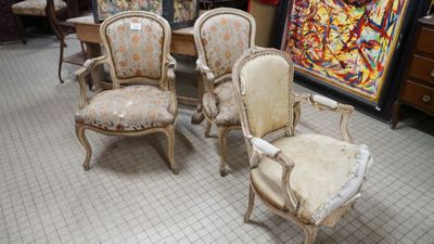 several chairs and a table in a room with a painting on the wall