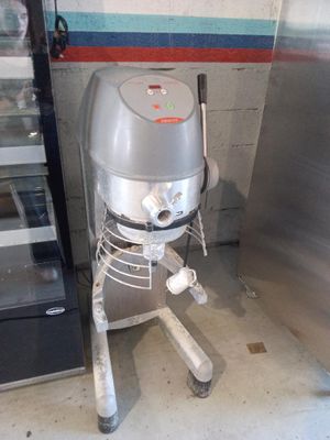 a silver mixer sitting next to a refrigerator in a kitchen