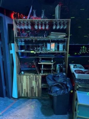 une pièce dans laquelle se trouve une étagère sur laquelle sont posés des verres à vin