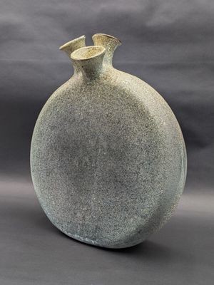 a gray vase that is sitting on a table