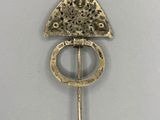 une image représentant une broche en or surmontée d'un triangle