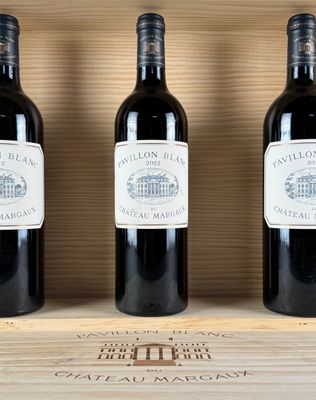 three bottles of wine sit on top of a wooden box
