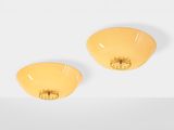 a pair of yellow earrings sitting on top of a white surface