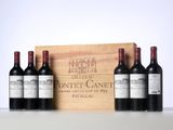 three bottles of red wine in front of a wooden box