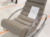 un fauteuil inclinable sur lequel est accrochée une pancarte, dans un showroom
