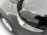 a reflection of a person in the side view mirror of a car