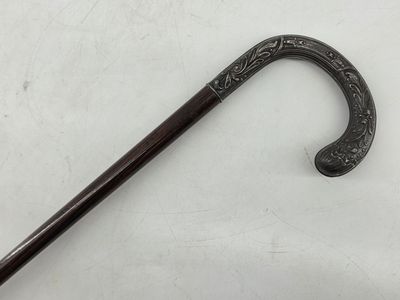 a black cane with a handle on a white surface