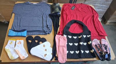 une table sur laquelle sont posés de nombreux vêtements et chaussures