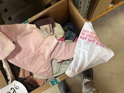 a box full of clothes that is sitting on the floor
