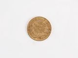 a gold coin on a white surface with a white background