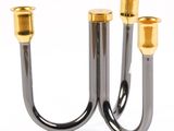 pair of black and gold candlesticks on a white background
