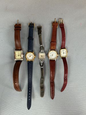 quatre montres différentes sont alignées sur une surface blanche