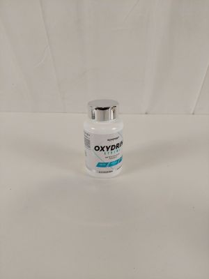une bouteille d'Oxyx posée sur une surface blanche