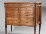 une commode ancienne ornée de sculptures raffinées sur le dessus