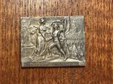 a close up of a metal plaque on a wooden surface
