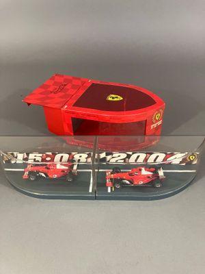 un gros plan d'une petite voiture rouge posée sur une table transparente