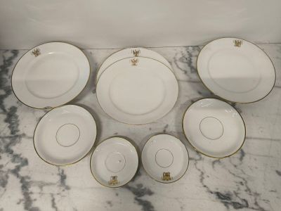 a group of white and gold plates on a marble table