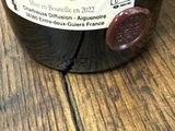 une bouteille de vin posée sur une table, avec une étiquette dessus