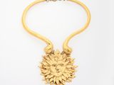an image of a gold necklace with a sunflower on it