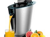 un extracteur de jus à côté duquel se trouve un verre de jus d'orange
