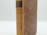 an old book sitting on top of a white surface