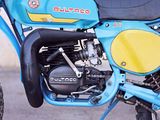 a blue and yellow motorcycle parked on the side of the road