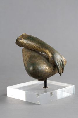 sculpture en bronze représentant une main tenant un oiseau, posée sur un socle transparent