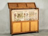 a wooden chest with pictures on it in a room