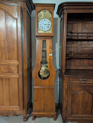 une horloge de parquet posée à côté d'un grand meuble en bois