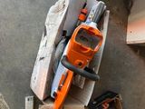 une tronçonneuse posée sur une pile de cartons