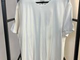 un t-shirt blanc accroché à un portant dans une pièce