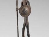 statue of a man with a spear and shield on a stone base