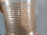 a silver vase with a gold design on it
