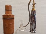 a glass container with a metal handle next to a glass bottle with a cork stopper