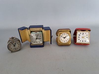 three different clocks are sitting next to each other on a table