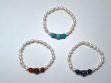 three bracelets with different colored beads on a white surface