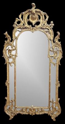 un miroir au cadre doré ouvragé sur fond noir