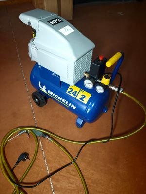 a blue and white air compressor sitting on the floor