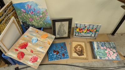 many paintings on a table with pictures on it