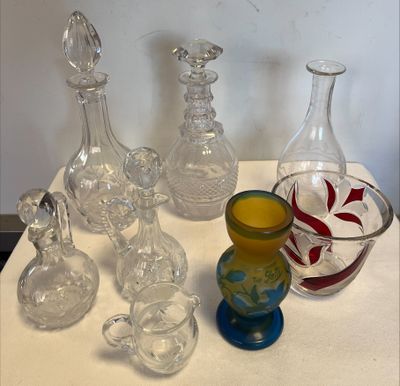 de nombreux vases en verre posés sur une table, avec un bol de jus d'orange