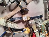 a pile of assorted watches on a white surface