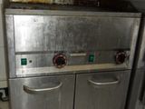 a silver stove in the middle of a white tiled kitchen