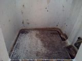 a dirty bathroom with a toilet and a dirty floor