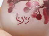 a hand holding a glass vase with flowers painted on it